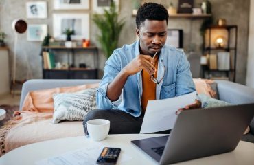 Person with a neutral expression looking at documents.